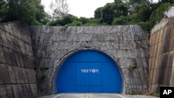In this Aug. 9, 2018 photo, a set of bright blue doors covers the entrance of the tunnel that holds the farm NextOn in Okcheon, South Korea.(AP Photo/Han Myung Oh)