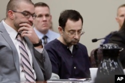 FILE - Larry Nassar sits with attorney Matt Newburg during his sentencing hearing in Lansing, Michigan, Jan. 24, 2018.