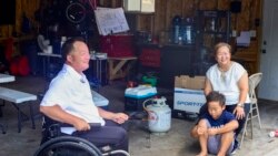 Sunisa Lee’s parents, John Lee (L) and Yang Thao (R), and Lucky Lee her younger brother talk with VOA Thai during an interview at their home in Saint Paul, Minnesota.