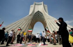 Warga Iran menginjak bendera AS dalam aksi unjuk rasa di alun-alun Azadi (Kebebasan) ibu kota Teheran, menandai hari al-Quds (Yerusalem), 7 Mei 2021.