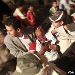 Demonstran anti pemerintah membawa rekannya yang terluka akibat penindakan oleh pasukan pemerintah di kota Taiz.