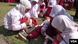 Siswa-siswa SDN Jejeran Yogyakarta berlatih pertolongan pertama pada kecelakaan. (S. Schonhardt/VOA)