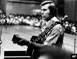 FILE - In this undated photo, Country singer George Jones is shown performing with his guitar.