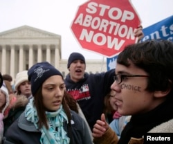 FILE - A pro-choice supporter is confronted by anti-abortion demonstrators in front of the U.S. Supreme Court in Washington January 22, 2007.