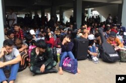 FILE - Myanmar workers wait before leaving Thailand at Mae Sot Immigration office in Tak province Thailand, July 3, 2017.