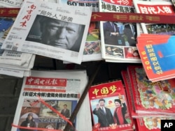 FILE - front page of a Chinese newspaper with a photo of U.S. President-elect Donald Trump and the headline "Outsider counter attack" is displayed at a newsstand in Beijing, China.