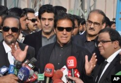 In this Tuesday, Jan. 2, 2018, photo, Pakistan's opposition leader Imran Khan, center, speaks to the media in Islamabad, Pakistan.