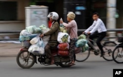 지난 16일 캄보디아 프놈펜에서 오토바이 택시 운전수가 손님과 짐을 오토바이에 태우고 이동하고 있다.
