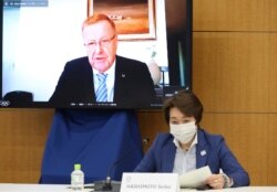 Komite Olimpiade Internasional, Wakil Presiden IOC John Coates nampak di layar televisi, sementara Ketua Panitia Olimpiade Tokyo 2020 Seiko Hashimoto mendengarkan keterangannya pada pertemuan Komisi Koordinasi IOC untuk Olimpiade Tokyo 2020 di Tokyo, Rabu, 19 Mei 2021.