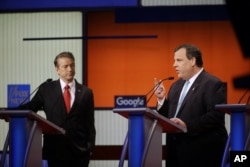 Chris Christie makes a point as Rand Paul listens during a Republican presidential primary debate in Des Moines, Iowa, Jan. 28, 2016.