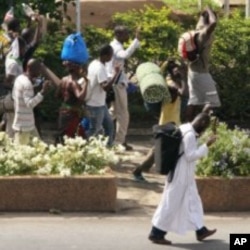 Civilians flee with their belongings in Abidjan, Ivory Coast, April 5, 2011
