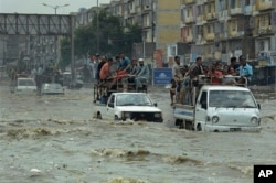 Pakistani commuters travel on a flooded street following a heavy rainfall in Karachi, Pakistan, Thursday, Aug. 31, 2017.