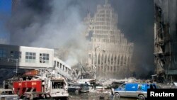 Terror hücumu nəticəsində dağıdılmış Dünya Ticarət Mərkəzinin qarşısında yanğınsöndürən maşınlar dayanıb. 11 sentyabr, 2001.