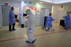 Health worker wearing protective suits to protect from coronavirus work at a nursing home, in Madrid, Spain, Tuesday, March 31, 2020.