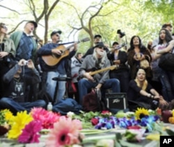 People sing John Lennon and Beatles songs as they gather around the Imagine mosaic in Strawberry Fields in New York's Central Park to celebrate the birthday of John Lennon in New York, October 9, 2010.