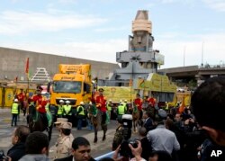 FILE - The statue of Egyptian Pharaoh Ramses II is surrounded by honor guards as it is moved to its permanent home at the Grand Egyptian Museum in Cairo, Egypt, Jan. 25, 2018.