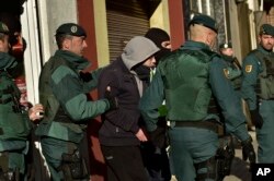FILE - A unidentified Moroccan leaves a tea shop detained by the Spanish Civil Guard in Pamplona, northern Spain, Dec.1, 2015. Spanish authorities alleged the man was a member of a cell that recruited fighters for the Islamic State group in Syria.