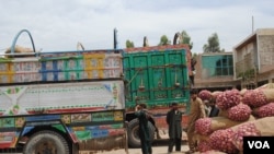 Truckers and their assistants wait in Jalalabad's heat as produce is loaded onto trucks headed across the border into Pakistan, May 16, 2012. (Bethany Matta/VOA)