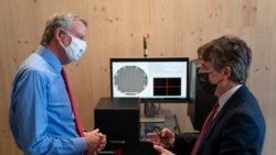 FILE - In this April 28, 2021 file photo, New York Mayor Bill de Blasio, left, speaks with Matthew Putman, co-founder and CEO of Nanotronics, during a facility tour before a ribbon-cutting ceremony to mark the opening of a Nanotronics manufacturing facility.