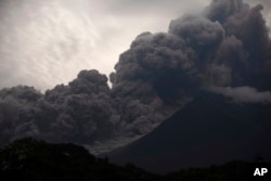 Volcan de Fuego, or Volcano of Fire, blows outs a thick cloud of ash, as seen from Alotenango, Guatemala, Sunday, June 3, 2018. (AP Photo/Santiago Billy)