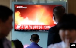 People watch a TV news program showing a file image of a missile launch conducted by North Korea, at the Seoul Railway Station in Seoul, South Korea, May 14, 2017. A missile was fired from near Kusong in North Phyongan province.