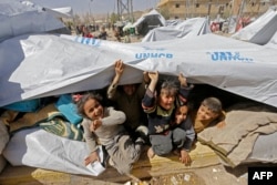 Syrian children, evacuated from rebel-held areas in eastern Ghouta, play at a shelter in the regime-controlled Adra district, on the northeastern outskirts of the capital Damascus, March 20, 2018.