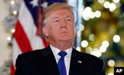 FILE - President Donald Trump listens people speak in support of Republican tax policy reform, during an event in the Grand Foyer of the White House, Dec. 13, 2017, in Washington.