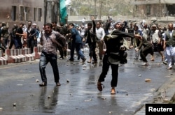 Afghans throw stones towards security forces during a protest in the wake of a deadly bombing Wednesday, in Kabul, Afghanistan, June, 2, 2017.