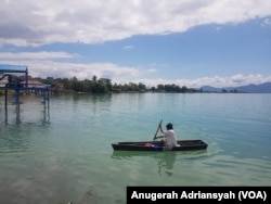 Seorang warga kecamatan Nainggolan, Pulau Samosir tengah mengayuh sampan di Danau Toba, Sumatera Utara. (Foto: VOA/Anugerah Adriansyah)