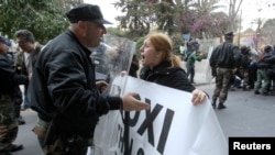 A protester tries to pass a police cordon during a rally by bank employees in Nicosia, Mar. 21, 2013.