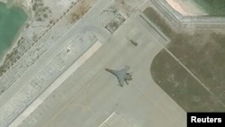 FILE - Satellite imagery shows the deployment of several new weapons systems, including a J-11 combat aircraft, at China’s base on Woody Island in the Paracels, South China Sea, May 12, 2018.