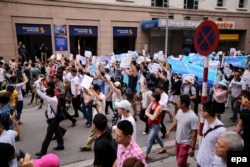 FILE - Vietnamese protesters take to the street during a rally denouncing recent mass fish deaths in Vietnam's central province, in Hanoi, Vietnam, May 1, 2016.