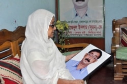Hajera Khatun with the photo of her son, Sajedul Islam Shumon, who became a victim of enforced disappearance in 2013. (Abdur Rajjak/VOA)