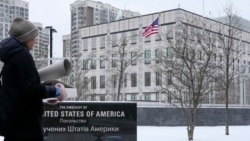 A woman walks past the U.S. Embassy in Kyiv, Ukraine, Monday, Jan. 24, 2022. (AP Photo/Efrem Lukatsky)