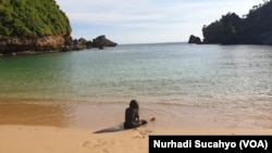 Seorang anak bermain sendirian di Pantai Ngrenehan, Yogyakarta yang sepi dalam periode liburan Nataru 2021. (Foto: VOA/Nurhadi)