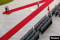 German Chancellor Angela Merkel and Chinese Premier Li Keqiang review the guard of honor during a welcome ceremony at the Chancellery in Berlin, Germany, May 31, 2017.
