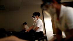 A therapist wearing a face shield does traditional Thai massage to a customer in a Health Land brach massage house which reopened after the Thai government eased isolation measures to prevent the spread of the coronavirus disease (COVID-19) in Bangkok, Th