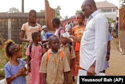 A health care worker takes the temperatures of school children for signs of the Ebola virus in Conakry, Guinea