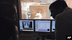 A medical team at Baptist Cardiac & Vascular Institute in Miami, Florida analyze CT scan images on January 30, 2007. (AP Photo/David Adame)