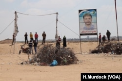 Young men stare out at the border of Israel, where tanks and military points surround the Gaza Strip, May 15, 2018.