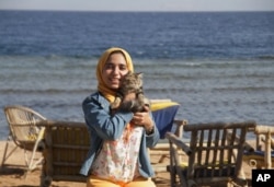 In this photo provided by el-Taweel family, Aug. 7, 2015, jailed Egyptian photographer Esraa el-Taweel poses for a photo in Egypt's Dahab beach in 2015.