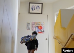 A student stops to bow to a portrait of Japanese former Emperor Hirohito and Empress Kojun at Tsukamoto kindergarten in Osaka, Japan, Nov. 30, 2016.