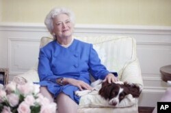 First lady Barbara Bush poses with her dog Millie in 1990.