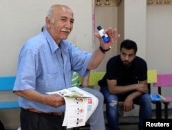 A man carries a ballot papers in a polling station located in a school during elections in Istanbul,Turkey, June 24, 2018.