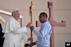 Pope Francis receives a cross made by an inmate at the CeReSo No. 3 prison in Ciudad Juarez, Mexico, Feb. 17, 2016.