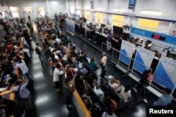 Immigrants wait in line inside the building of National Migration Directorate, in Buenos Aires, Argentina, Feb. 22, 2018.