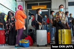 Buruh migran Indonesia tiba dari Malaysia di pelabuhan Bandar Sri Junjungan di Dumai, Riau pada 2 April 2020, setelah Indonesia menyatakan keadaan darurat pada 31 Maret akibat virus corona melonjak. (Foto: AFP/Iwan CKN)
