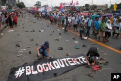 Protesters scatter pairs of slippers and shoes to symbolize victims killings in the so-called war on drugs of President Rodrigo Duterte.