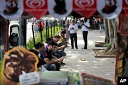 FILE - Indians use their mobile phones in New Delhi, India, Sept. 22, 2015.