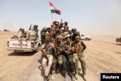 Iraq's Shi'ite paramilitaries ride in military vehicles in Nibai, May 26, 2015.